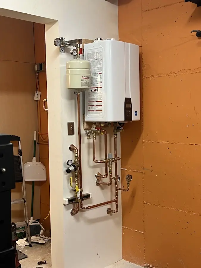 Plumbing technician inspecting water heater connections in Cudahy